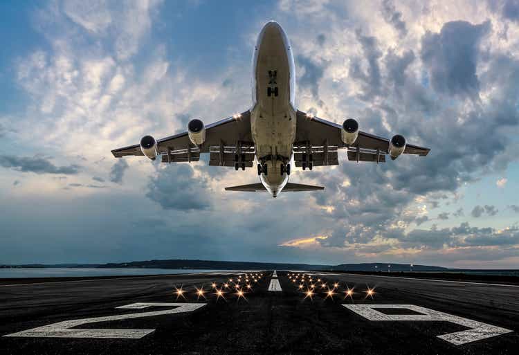 Passenger plane taking off at sunset
