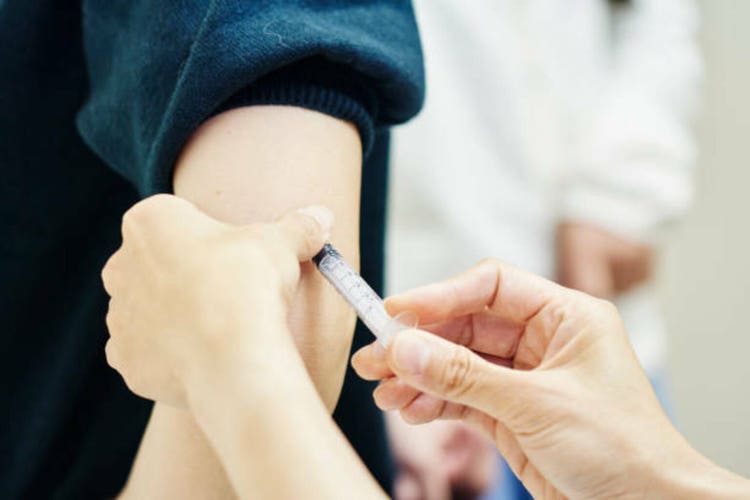 Female doctor giving a vaccination shot to a young woman