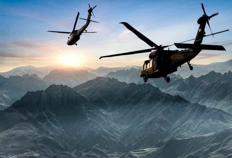 Militärhubschrauber fliegen gegen Sonnenuntergang