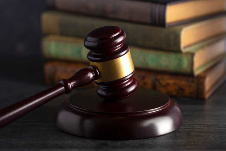 Wooden Judges Gavel on a Desk with Books in the Background