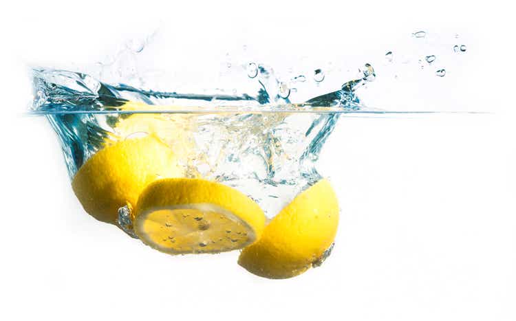 lemon slices fall into the water with splash, isolated on a white background, copy space