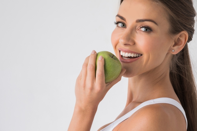 Woman biting green apple