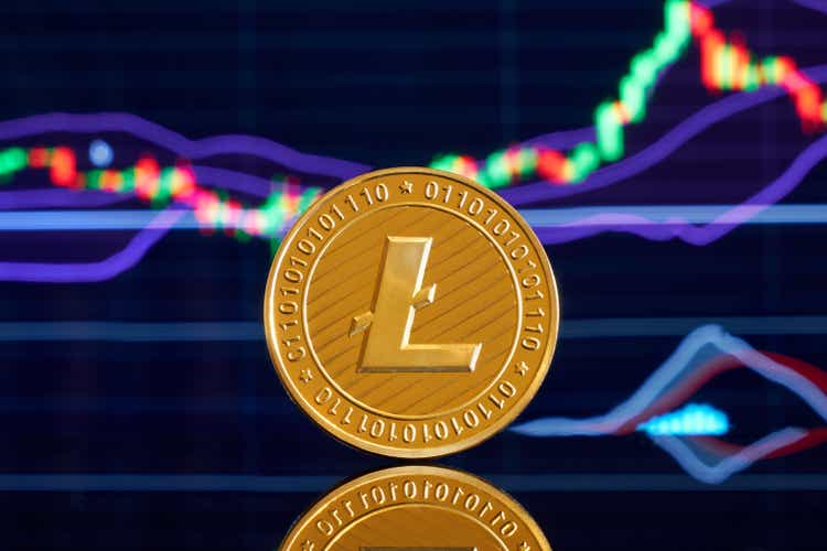 Golden litecoin coins on a shiny background close-up with business graphics. Cryptocurrency. Anonymous. Virtual currency