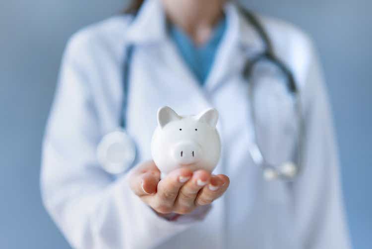 Doctor holding piggy bank