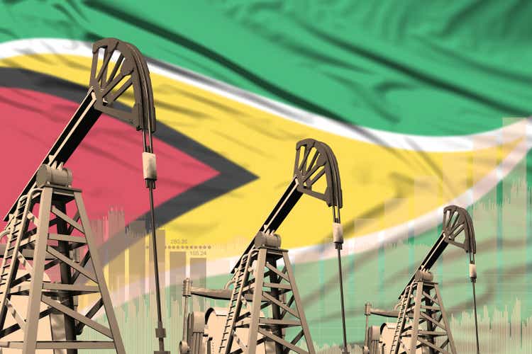 industrial illustration of oil wells - Guyana oil industry concept on flag background. 3D Illustration