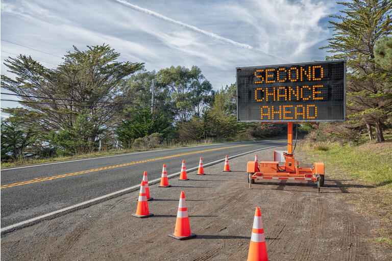 TWEEDE kans vooruit: weg teken: Trailer mobiele waarschuwingsbord geparkeerd door de weg met woorden voor de veiligheid door oranje kegels