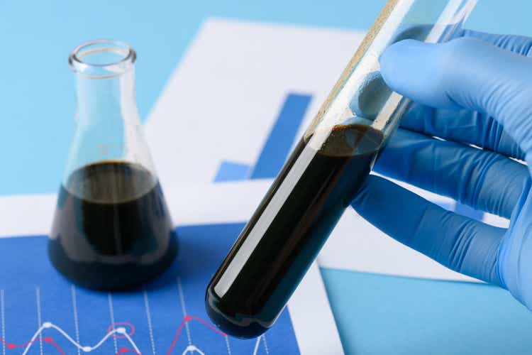 Lab test crude oil in vial in scientist hand