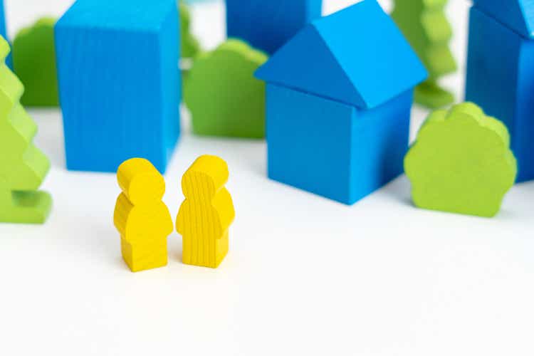 Miniature people: Wooden couple on the street of City with wooden blocks houses on the background. Image use for find the answer of question, education , business concept.