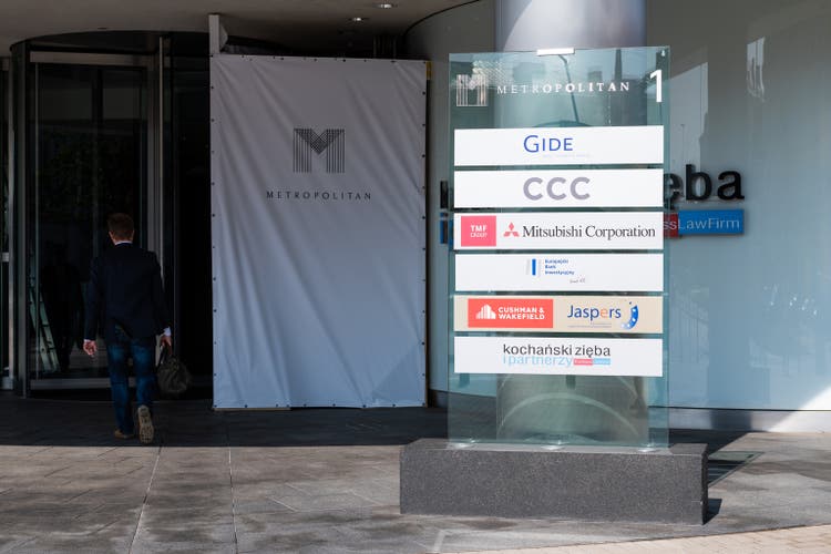 Exterior of Metropolitan modern business center with sign for companies such as Gide, CCC and Mitsubishi corporation