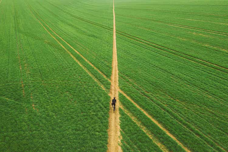 Drone view of cyclist on path through field