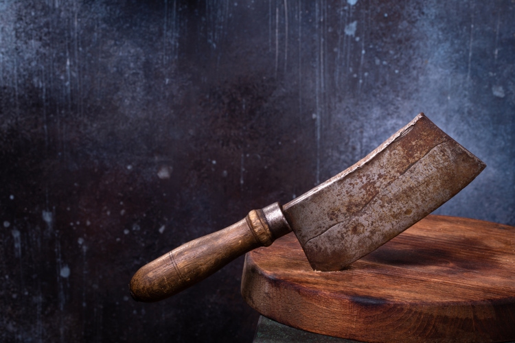 Meat cleaver cut in board