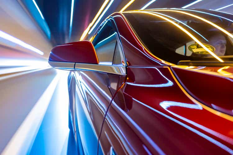 electric powered car drives on city street while night