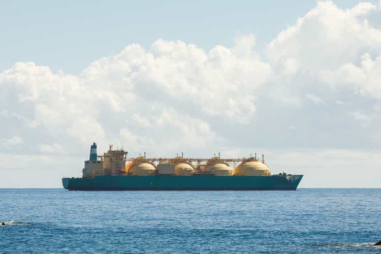 liquefied natural gas LNG transportation tanker ship, blue sea and sunny sky background