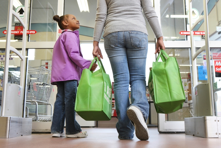 Mom and daughter walking out of grocery store.