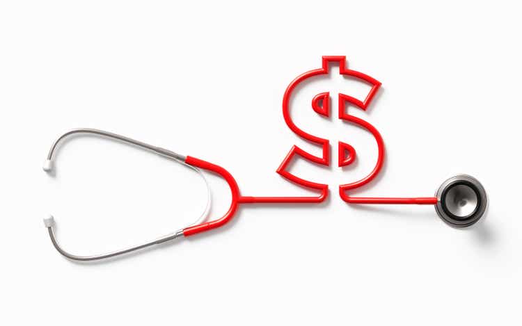 Red Stethoscope Forming An American Dollar Sign On White Background