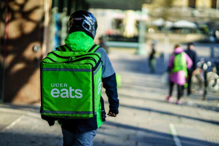 Uber eats delivery person carrying food to people who order by online app