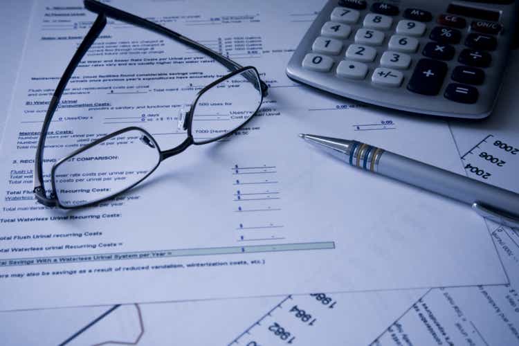 Glasses, calculator and pen on Financial cost documents