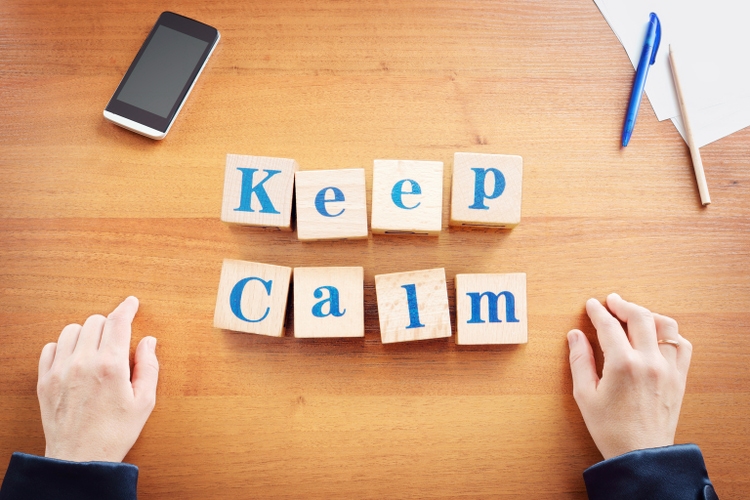 Keep calm. Business woman made text from wooden cubes on a desk