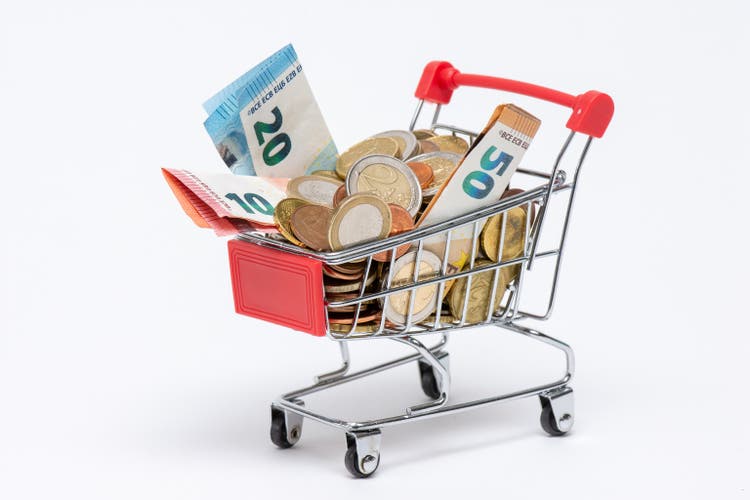 Shopping cart full of euro coins and banknotes