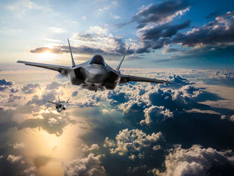 F-35 Fighter Jets flying over the clouds at sunset