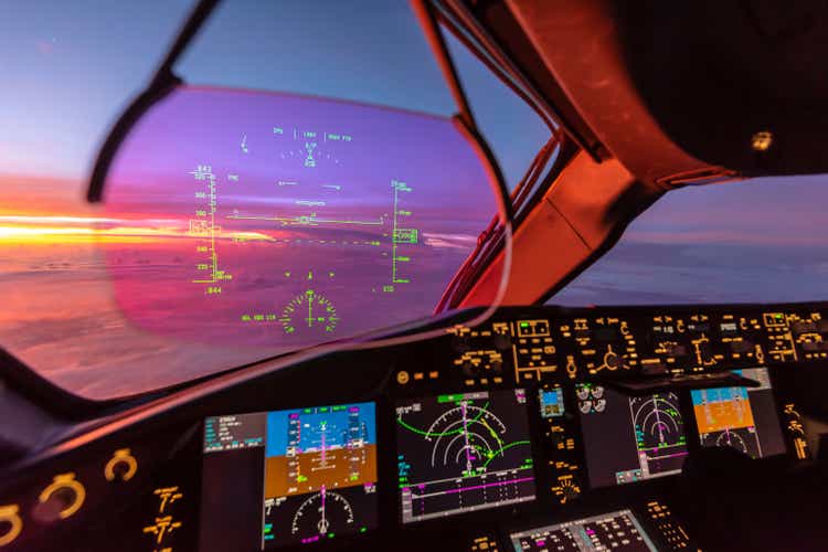 Sunrise view from modern aircraft cockpit with Heads up Display and flight instruments