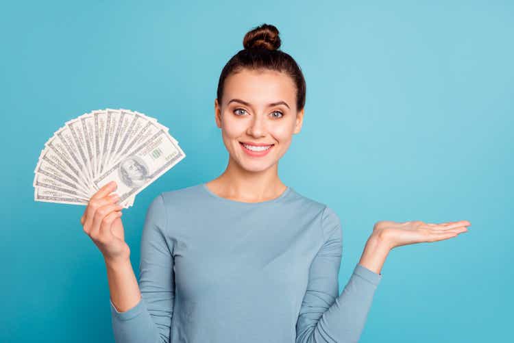 Portrait positive cheerful excited enjoy lady stylish beautiful banknote millionaire have promo sale discount choice ad decision feedback present notice wear modern sweater isolated blue background