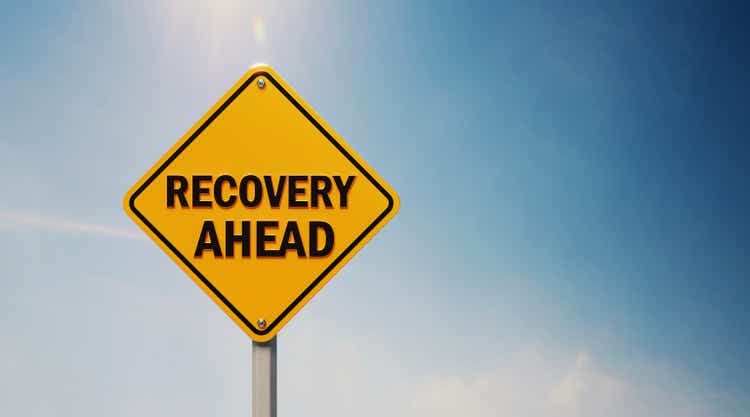 Yellow Off Road Traffic Sign With Recovery Ahead Text on Blue Sky