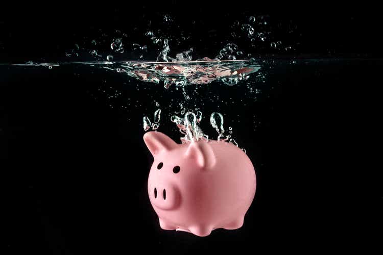 Crisis concept, drowning piggy bank