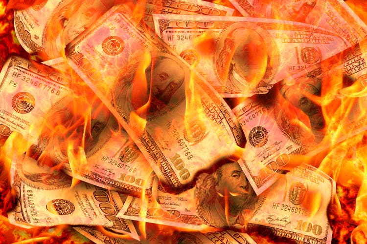Dollars Banknotes or bills of United States of America dollars burning in flame concept of crisis, loss, recession or failure