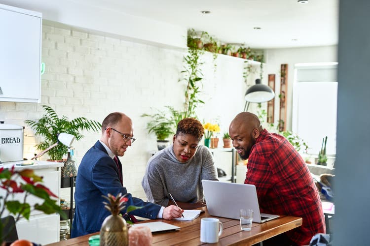 Couple listening to financial advisor at home with laptop