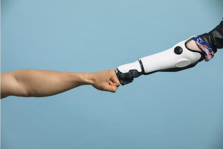 A Human and Robotic Arm Making a Fist Bump