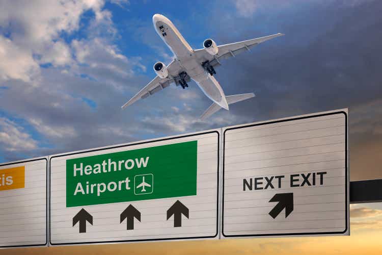 Road sign indicating the direction of Heathrow airport and a plane that just got up.