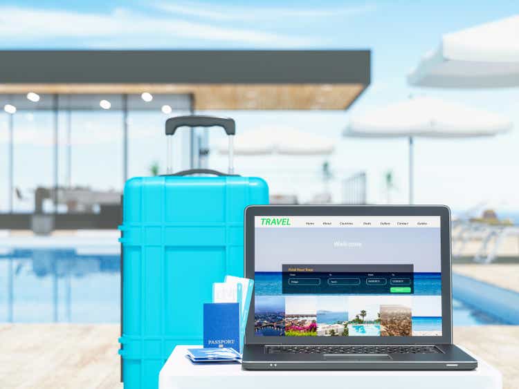 Laptop with suitcase near the luxury resort. Concept of travel.