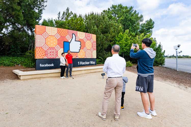 Tourists posing in front of the Facebook Like Button