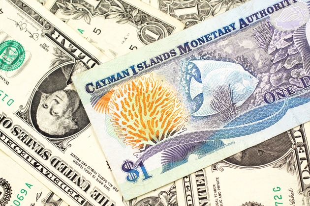 A Cayman Islands dollar bill with American one dollar bills