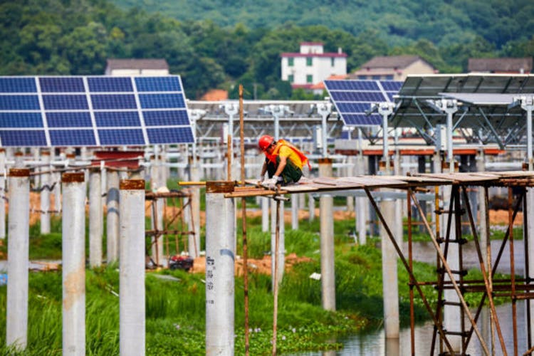 Workers are installing solar photovoltaic panels on the lake