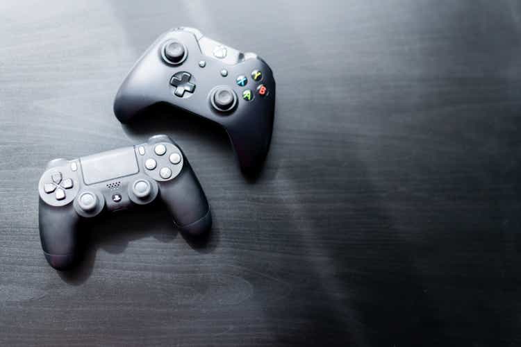 Контроллер Xbox и Playstation сидел рядом друг с другом на темном фоне