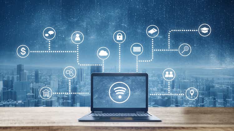 Ordenador portátil en escritorio de madera con Wireless y programación de aplicaciones e iconos de redes sociales. Las redes de Internet y la tecnología inalámbrica