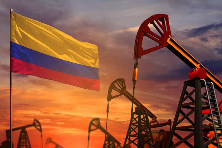 Colombia oil industry concept. Industrial illustration - Colombia flag and oil wells with the red and blue sunset or sunrise sky background - 3D illustration