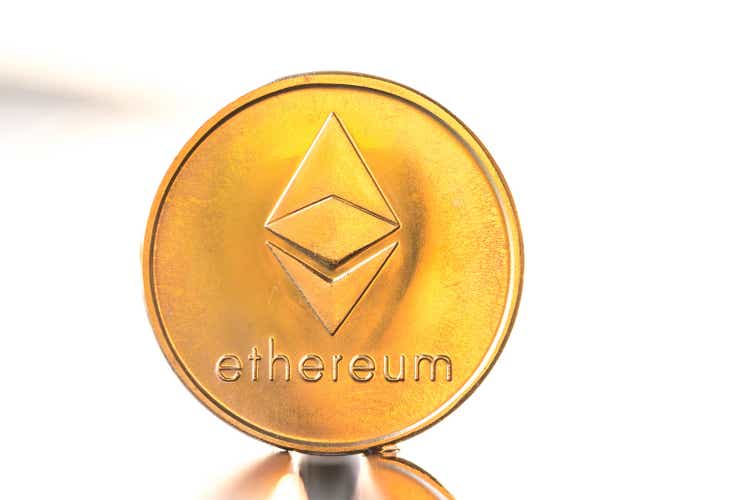 Ethereum gold color coin with sunset white background. Cryptocurrency virtual coin.