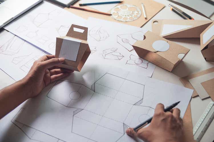 Designer sketching drawing design Brown craft cardboard paper product eco packaging mockup box development template package branding Label . designer studio concept .