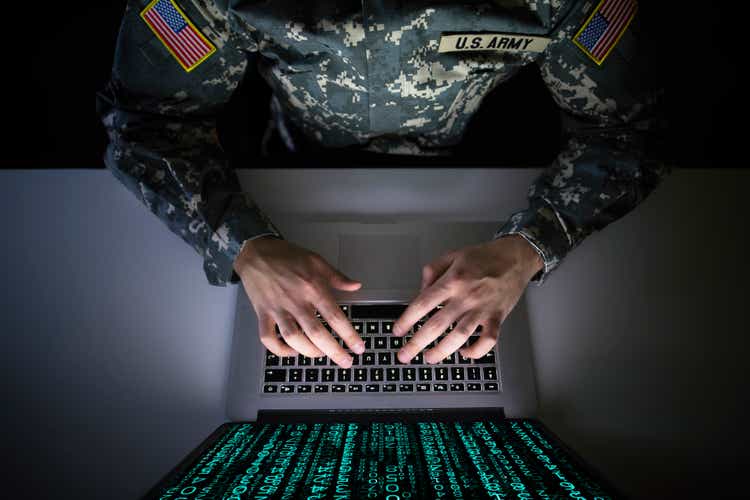 American soldier in military uniform preventing cyber attack in military intelligence center. An US officer intercepting messages to stop terrorism. Modern warfare system surveillance concept.