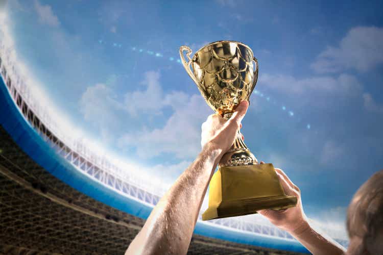 Athlete holding trophy cup above head in stadium