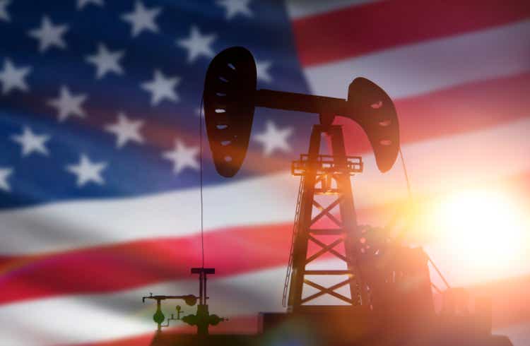 silhouette of oil drilling pump on background of united states flag.