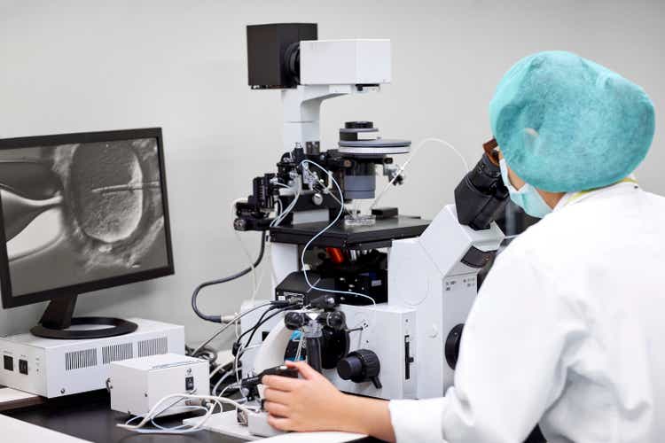 Scientist looking in microscope at laboratory