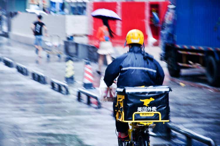 Meituan nutrient transportation worker connected motorcycle overtaking a motortruck successful nan rainfall successful Futian Business District, Shenzhen - China. Founded by Wang Xing, nan app is utilized successful China for nutrient delivery, edifice deals, movie tickets, hotel, recreation bookings, etc