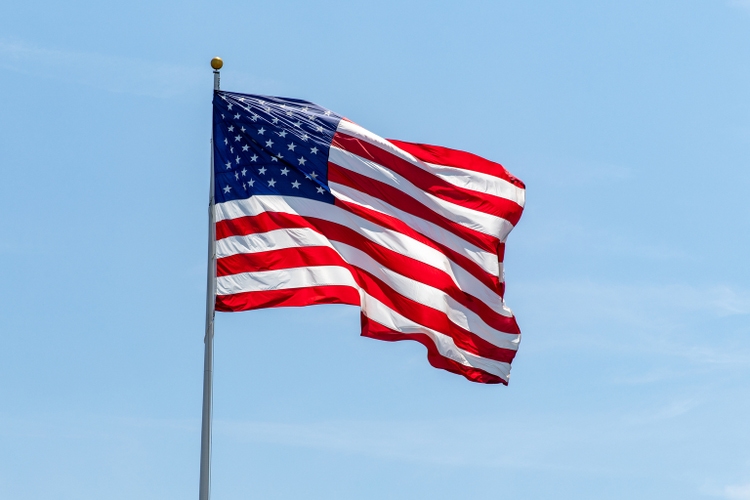 Amerikaanse vlag zwaaiend op pole met heldere levendige rode Whie en blauwe kleuren