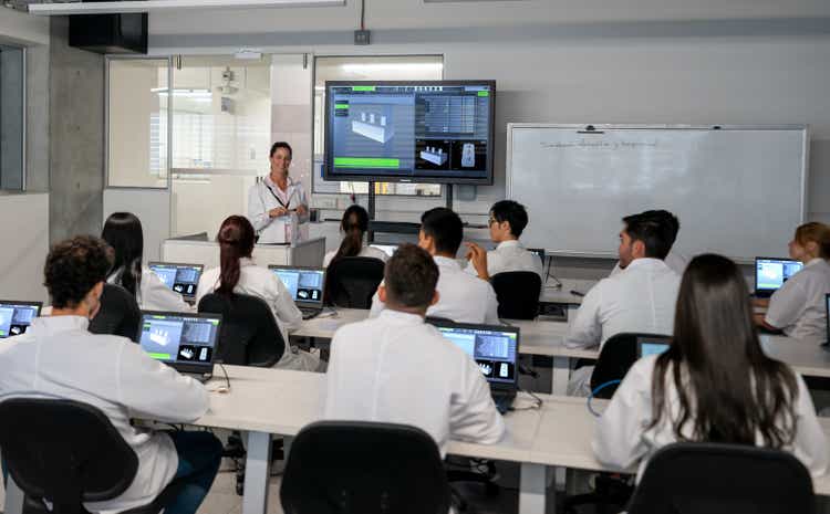 Latin American teacher teaching design in computer lab to a large group of students