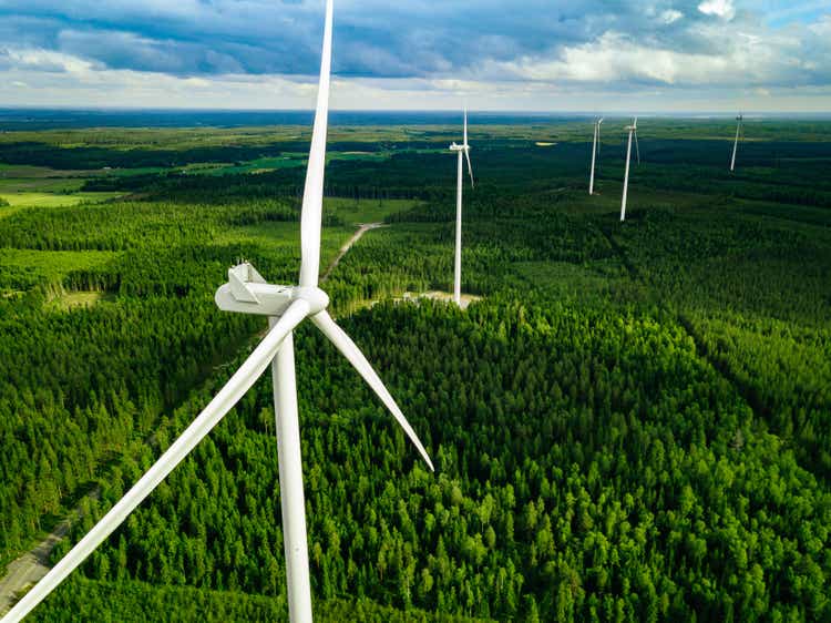 Aerial view of windmill in summer forest in Finland.  Wind turbines for clean electricity and renewable energy