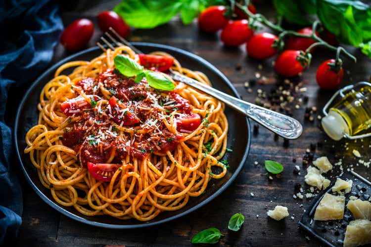 Spaghetti with tomato sauce shot on rustic wooden table